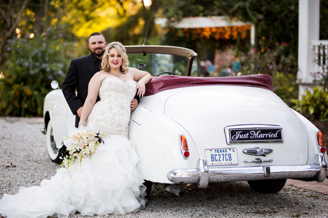 portrait of bride and groom in front of car