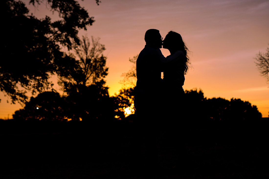 silhouette of couple kissing and dusk