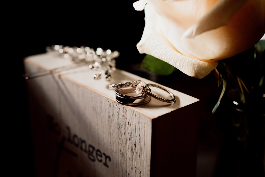 close up of wedding rings on flower box