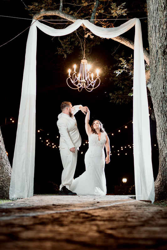 bride and groom dancing under chandelier 