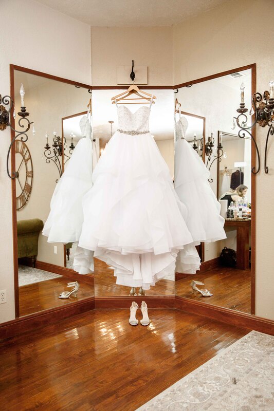 Wedding dress hanging from large mirror