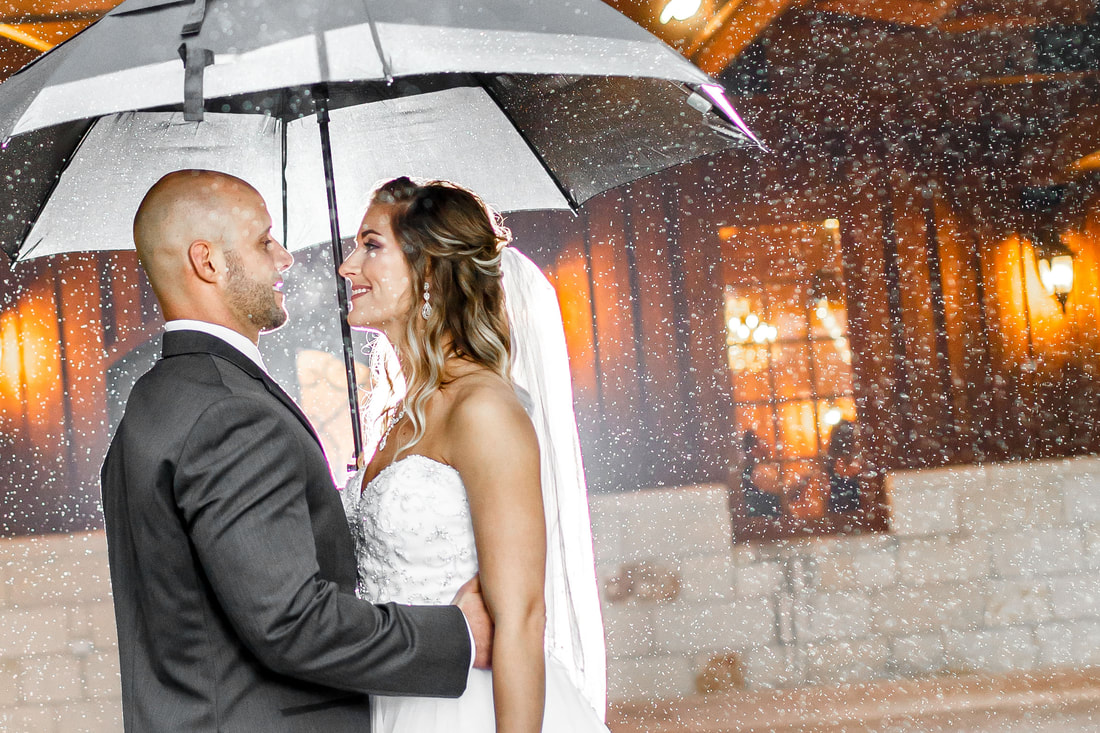 Wedding couple laughing in the rain 